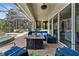 Covered patio with stylish seating area, outdoor kitchen, and a view of the pool and tropical landscaping at 186 Portofino Dr, Nokomis, FL 34275