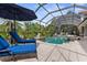 Inviting screened pool area with lounge chairs and a sun umbrella, perfect for relaxation and enjoying the outdoors at 186 Portofino Dr, Nokomis, FL 34275
