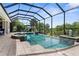 Inviting screened-in pool with spa and lush tropical landscaping offering a private outdoor oasis at 186 Portofino Dr, Nokomis, FL 34275