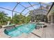 Beautiful screened pool and spa with lion statues, surrounded by lush greenery, offering a private oasis at 186 Portofino Dr, Nokomis, FL 34275