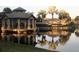 View of The Venice Golf and Country Club entrance near a pond with gazebo, and lush palm trees at 201 Vestavia Dr, Venice, FL 34292