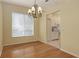 Light-filled dining room featuring hardwood floors, a chandelier, and adjacent kitchen access at 201 Vestavia Dr, Venice, FL 34292
