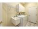 Bright laundry room with a washing machine, dryer, utility sink, and storage at 201 Vestavia Dr, Venice, FL 34292