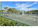 Well-maintained tennis courts with players enjoying a match under the bright, sunny sky surrounded by green foliage at 201 Vestavia Dr, Venice, FL 34292