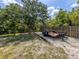 Gravel parking area with a trailer and wooded backdrop at 2020 E Crest Dr, Englewood, FL 34223
