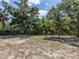 Spacious backyard with a treed backdrop and outdoor firepit at 2020 E Crest Dr, Englewood, FL 34223