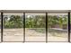 View from screen-in patio to the large, treed backyard at 2020 E Crest Dr, Englewood, FL 34223