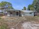 View of screened-in patio with ceiling fan, patio and a grill in the backyard at 2020 E Crest Dr, Englewood, FL 34223