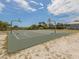 Outdoor basketball court near the beach, surrounded by palm trees and a wooden fence at 2020 E Crest Dr, Englewood, FL 34223