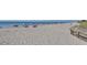 Expansive beach view featuring a boardwalk leading to the sandy shore, perfect for beachgoers at 2020 E Crest Dr, Englewood, FL 34223