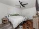 Modern bedroom featuring a black ceiling fan, wood-look floors, and a decorative hide rug at 2020 E Crest Dr, Englewood, FL 34223