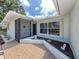 Close up of front entrance featuring welcome mat, window, and landscaping at 2020 E Crest Dr, Englewood, FL 34223