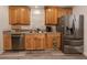 Bright kitchen featuring stainless steel appliances, a double sink, wood cabinets, and gray vinyl flooring at 2020 E Crest Dr, Englewood, FL 34223
