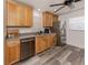 Bright kitchen featuring stainless steel appliances, double sink, wood cabinets, and gray vinyl flooring at 2020 E Crest Dr, Englewood, FL 34223