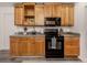 Updated kitchen with wood cabinets, a microwave, black oven, and gray vinyl flooring at 2020 E Crest Dr, Englewood, FL 34223