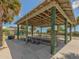 Covered picnic pavilion with picnic tables, surrounded by lush greenery and trees at 2020 E Crest Dr, Englewood, FL 34223