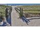 Path to the beach featuring sand, grass and fencing leading towards the sunny ocean at 2020 E Crest Dr, Englewood, FL 34223