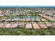 Aerial shot showcasing a community with waterfront properties and tile roofs surrounded by lush greenery at 2034 Mesic Hammock Way, Venice, FL 34292