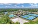 Aerial shot showcasing the pool, tennis courts, volleyball court and lush green landscaping surrounding the community at 2034 Mesic Hammock Way, Venice, FL 34292