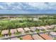 Aerial view of the neighborhood featuring well-maintained homes and green spaces against a scenic backdrop at 2034 Mesic Hammock Way, Venice, FL 34292