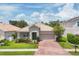 Beautiful home showcasing a clay tile roof, brick paver driveway, and lush front yard landscaping at 2034 Mesic Hammock Way, Venice, FL 34292