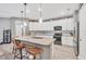 Beautiful kitchen featuring white cabinets, stainless steel appliances, and a granite island with bar stools at 2034 Mesic Hammock Way, Venice, FL 34292