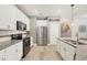 Modern kitchen with stainless steel appliances, granite countertops, white cabinets and light hardwood flooring at 2034 Mesic Hammock Way, Venice, FL 34292