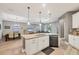 Open-concept layout with kitchen island, dining area, living room, and hardwood flooring at 2034 Mesic Hammock Way, Venice, FL 34292
