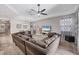 Open-concept living room featuring hardwood floors, a comfortable sectional sofa, and neutral decor at 2034 Mesic Hammock Way, Venice, FL 34292