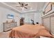 Bright main bedroom featuring tray ceilings, a ceiling fan, and carpet flooring at 2034 Mesic Hammock Way, Venice, FL 34292