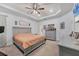 Bright main bedroom featuring tray ceilings, a ceiling fan, and carpet flooring at 2034 Mesic Hammock Way, Venice, FL 34292