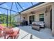 This inviting covered patio with comfortable seating is great for entertaining and enjoying the outdoors at 2034 Mesic Hammock Way, Venice, FL 34292