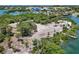 Aerial view of a sandy park with trees, surrounded by calm waters, showcasing recreational space at 205 Louella Ln, Nokomis, FL 34275