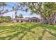 Expansive backyard featuring a large lawn, mature trees, and a charming patio area perfect for outdoor relaxation at 205 Louella Ln, Nokomis, FL 34275