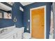 Cozy bathroom features stylish blue walls, white fixtures, and a classic medicine cabinet above the sink at 205 Louella Ln, Nokomis, FL 34275