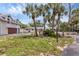 Exterior of home displaying a lush green lawn, beautiful palm trees, and a spacious driveway, perfect for curb appeal at 205 Louella Ln, Nokomis, FL 34275