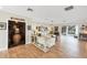 Open living room featuring wood floors, ample natural light, a wine nook, and elegant furnishings, creating a warm ambiance at 205 Louella Ln, Nokomis, FL 34275