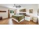 Bright main bedroom with wood floors, ceiling fan, and natural light at 205 Louella Ln, Nokomis, FL 34275