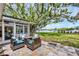Back patio area with plenty of comfortable seating, a view of the water and mature trees at 205 Louella Ln, Nokomis, FL 34275