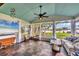 Bright sunroom with views of the lush backyard and water, featuring comfortable seating at 205 Louella Ln, Nokomis, FL 34275