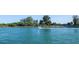 Picturesque waterfront view with a boat cruising on the calm, blue waters, surrounded by lush greenery at 205 Louella Ln, Nokomis, FL 34275