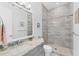 Bathroom featuring gray cabinets, granite countertops, and shower with patterned tile at 209 E Venice Ave, Venice, FL 34285