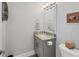 Half bath with gray vanity, granite countertop, framed mirror, and neutral decor at 209 E Venice Ave, Venice, FL 34285