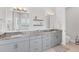 Bathroom featuring double sinks, granite countertops, modern fixtures, and a view of the backyard at 209 E Venice Ave, Venice, FL 34285