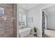 Bathroom featuring a freestanding tub, glass shower, and plantation shutters at 209 E Venice Ave, Venice, FL 34285