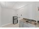 Laundry room featuring a granite countertop, sink, and stainless steel refrigerator at 209 E Venice Ave, Venice, FL 34285