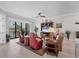 Bright living room with tile floors, modern furnishings, ceiling fan, and a balcony overlooking the water at 209 E Venice Ave, Venice, FL 34285