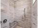 Shower features marble-look tiles, a granite bench, and a dual shower head at 209 E Venice Ave, Venice, FL 34285