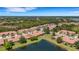 Picturesque aerial view highlighting a residential neighborhood with lush greenery and a serene pond at 2104 Batello Dr, Venice, FL 34292