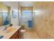 Bathroom with glass shower, handrails, neutral color palette, and tiled floor at 2104 Batello Dr, Venice, FL 34292